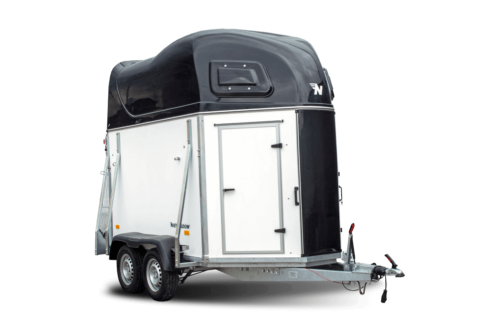 Hevostraileri maasturin perässä tallin pihassa